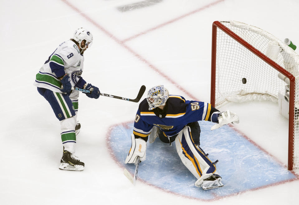 Vancouver Canucks' J.T. Miller (9) scores on St. Louis Blues goalie Jordan Binnington (50), although it was ruled no goal as the play was offside during the second period of a first-round NHL Stanley Cup playoff hockey series in Edmonton, Alberta, Friday Aug. 14, 2020. (Jason Franson/The Canadian Press via AP)