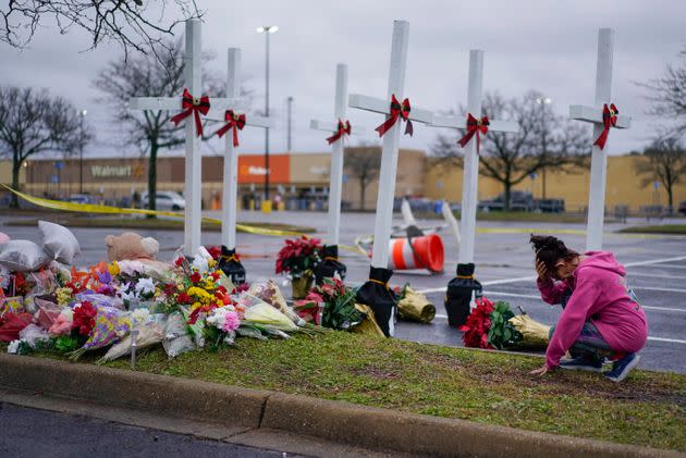 Robin Fisher of Chesapeake prays at a makeshift memorial in the parking lot of the Walmart Supercenter on Sunday.