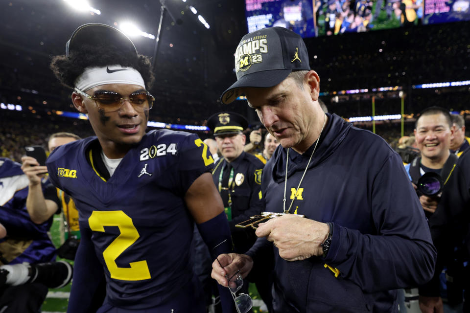 HOUSTON, TEXAS - JANUARY 08: Head coach Jim Harbaugh of the Michigan Wolverines celebrates with Will Johnson #2 after defeating the Washington Huskies during the 2024 CFP National Championship game at NRG Stadium on January 08, 2024 in Houston, Texas. Michigan defeated Washington 34-13. (Photo by Gregory Shamus/Getty Images)