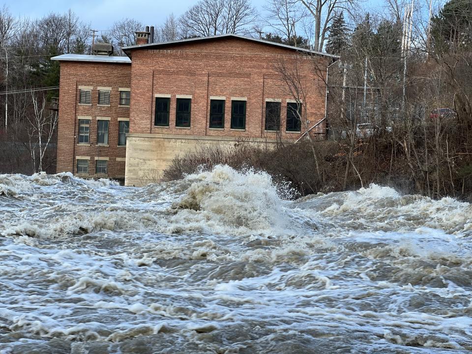 The Winooski River rages over the dam in Essex Junction and under Vermont 2-A the afternoon of Dec. 19, 2023 following a major rain and snowmelt event. The river reached 21 and a half feet, more than nine feet above flood stage at 12 feet.