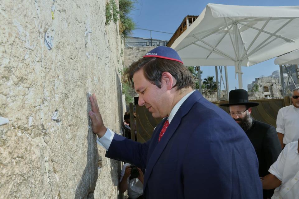 Gov. Ron DeSantis prays at the Western Wall in the Old City of Jerusalem in May. A common tradition is to insert handwritten notes and prayers into the cracks along the wall. The governor inserted his own plea to spare Florida from hurricanes this season.