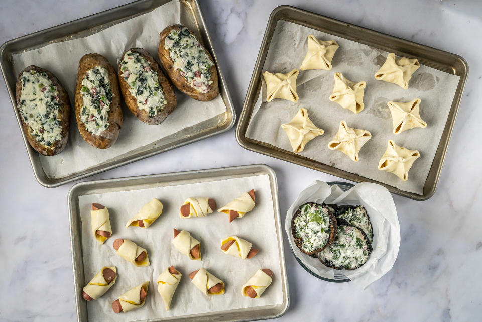 Frozen food ready to be stored: twice loaded baked potatoes, apple brie puffs, portobellos with goat cheese and pigs in a blanket. (Noah Fecks)