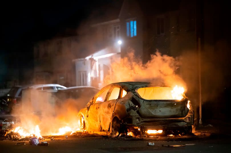 A car on fire during the Ely riots
