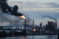 FILE - In this June 21, 2019 file photo, flames and smoke emerge from the Philadelphia Energy Solutions Refining Complex in Philadelphia. The owner of the largest oil refinery complex on the East Coast is telling officials that it will close the facility after a fire last week set off explosions and damaged the facility. Philadelphia Mayor Jim Kenney said in a Wednesday, June 26 statement that Philadelphia Energy Solutions has informed him of its decision. Kenney says the more than 1,000 workers there will be impacted. The 150-year-old oil refining complex processes 335,000 barrels of crude oil daily. (AP Photo/Matt Rourke, File)