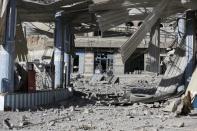 A man stands outside a shop at the site of a Saudi-led air strike in Yemen's capital Sanaa January 4, 2016. REUTERS/Khaled Abdullah