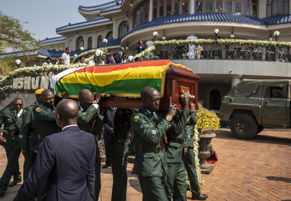 The casket of former president Robert Mugabe is carried by the presidential guard to an air force helicopter for transport to a stadium where it will lie in state, at his official residence in the capital Harare, Zimbabwe Friday, Sept. 13, 2019. The ongoing uncertainty of the burial of Mugabe, who died last week in Singapore at the age of 95, has eclipsed the elaborate plans for Zimbabweans to pay their respects to the former guerrilla leader at several historic sites. (AP Photo/Ben Curtis)