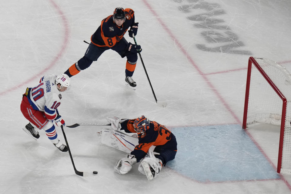 New York Rangers' Artemi Panarin, left, scores the winning goal past New York Islanders goaltender Ilya Sorokin, bottom, during the overtime period of an NHL Stadium Series hockey game in East Rutherford, N.J., Sunday, Feb. 18, 2024. (AP Photo/Seth Wenig)