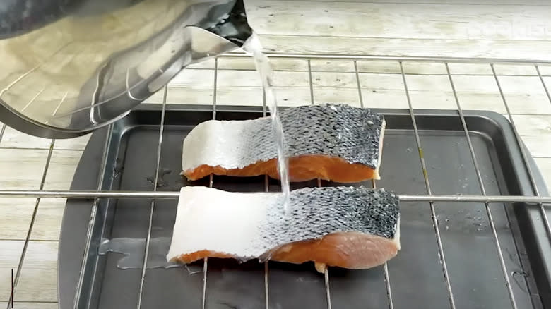 salmon skin being removed with water