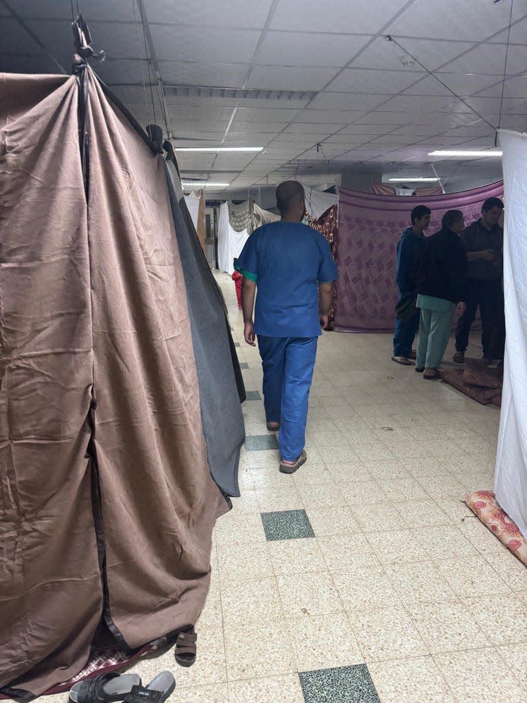 Sheets and blankets are attached to the ceiling to create makeshift rooms for patients as rooms fill up due to the overrun system at Gaza's European Hospital in late December 2023.