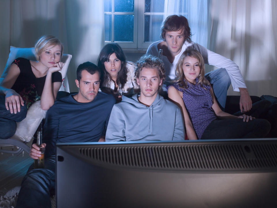 A group of young people watching TV together