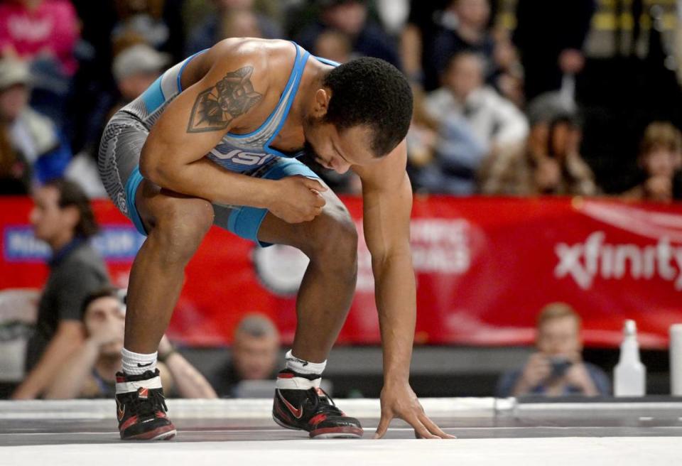 Mark Hall takes a moment after losing his consolation bout in the 86 kg weight during the U.S. Olympic Team Trials at the Bryce Jordan Center on Saturday, April 20, 2024. After the match Hall took off his shoes showing his retirement from competitive wrestling.