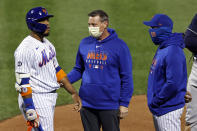 New York Mets' Robinson Cano, left, reacts as he is checked by a team trainer, center, after being hit by a pitch during the fourth inning of a baseball game against the Atlanta Braves, Friday, Sept. 18, 2020, in New York. Mets manager Luis Rojas, right, looks on. (AP Photo/Adam Hunger)