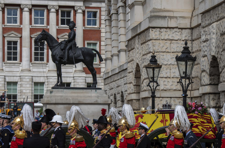 The coffin of Queen Elizabeth II, draped in the Royal Standard with the Imperial State Crown and the Sovereign's orb and scepter, passes through Horse Guards Parade during her state funeral in London, Monday, Sept. 19, 2022. The Queen, who died aged 96 on Sept. 8, will be buried in the George VI Memorial Chapel at Windsor alongside her late husband, Prince Philip, who died last year. (Chris J Ratcliffe/Pool Photo via AP)