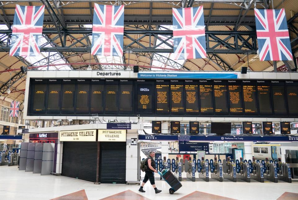 A man passes departure boards at Victoria station in London (Dominic Lipinski/PA) (PA Wire)