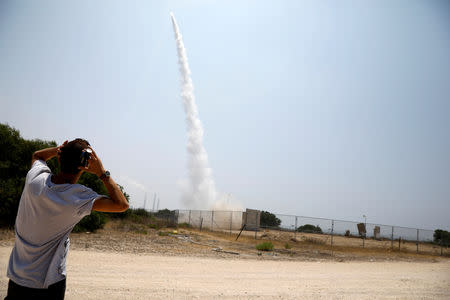An Israeli man looks on as an Iron Dome launcher fires an interceptor rocket in the southern Israeli city of Ashkelon July 14, 2018 REUTERS/Amir Cohen