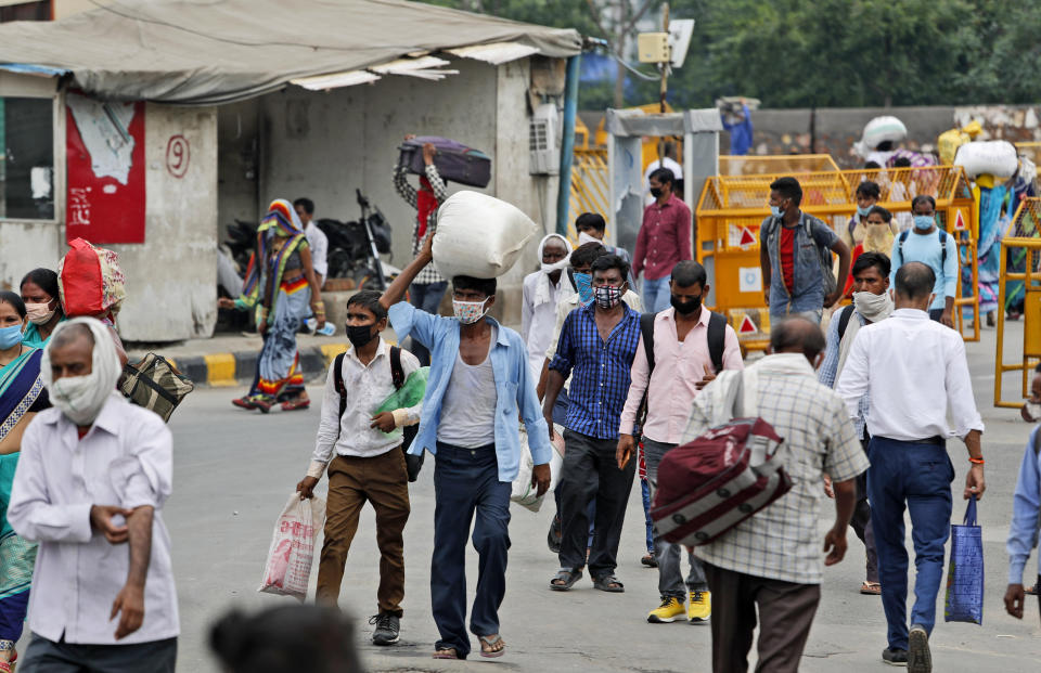 Migrant workers return with their belongings to look for work in New Delhi, India, Tuesday, Aug. 18, 2020. The lockdown imposed in late March cost more than 10 million impoverished migrant workers their jobs in the cities. Many made grueling journeys back to their hometowns and villages. Now they face the ordeal of trying to get back to their factory jobs. The government began easing a stringent two-month-long lockdown in June, but business is only a quarter to a fifth of usual and customers are scarce, said Praveen Khandelwal, general secretary of the Confederation of All India Traders. (AP Photo/Manish Swarup)