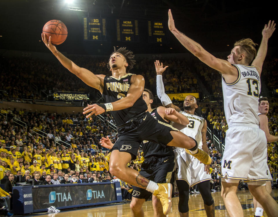 FILE - In this Dec. 1, 2018, file photo, Purdue guard Carsen Edwards, left, attempts a layup while defended by Michigan guard Zavier Simpson (3) and forward Ignas Brazdeikis (13) in the first half of an NCAA college basketball game, in Ann Arbor, Mich. Edwards was named to the All-Big Ten Conference team, Tuesday, March 12, 2019. (AP Photo/Tony Ding, File)