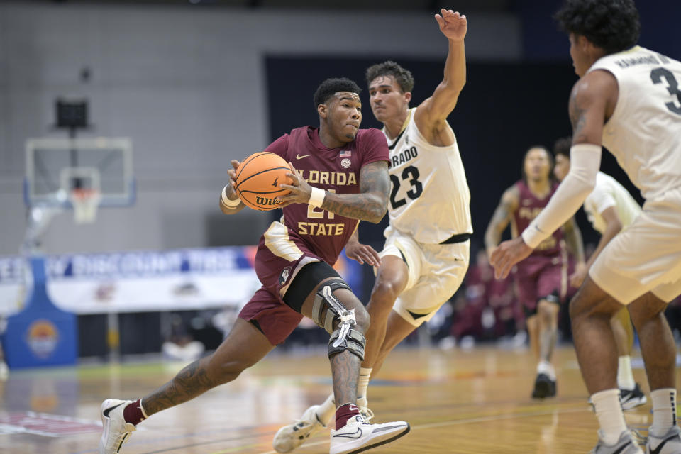 Florida State guard Cam'Ron Fletcher drives to the basket between Colorado forward Tristan da Silva (23) and guard Julian Hammond III during the first half of an NCAA college basketball game, Tuesday, Nov. 21, 2023, in Daytona Beach, Fla. (AP Photo/Phelan M. Ebenhack)