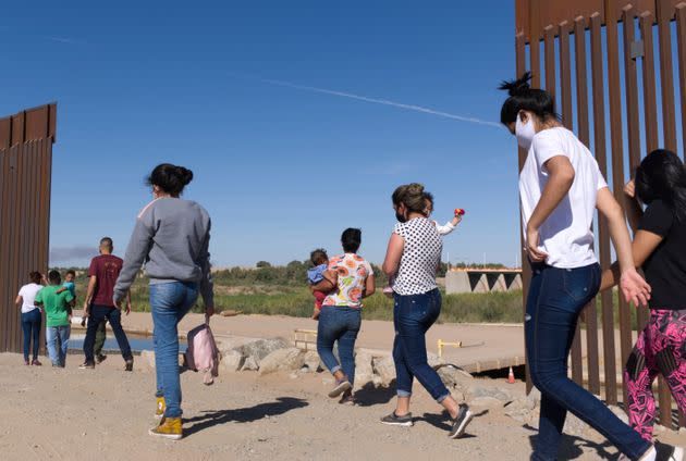 A group of Brazilian migrants make their way around a gap in the U.S.-Mexico border in Yuma, Ariz., seeking asylum in the United States. (Photo: Eugene Garcia/Associated Press)