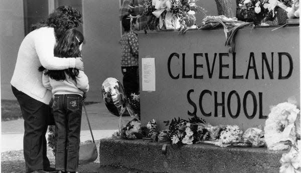 People look at flowers left on the Cleveland School campus the day after the shooting.