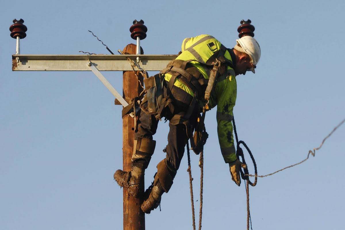 An archive photograph of a workman repairing a high voltage overhead line. <i>(Image: Danny Lawson/PA Wire)</i>