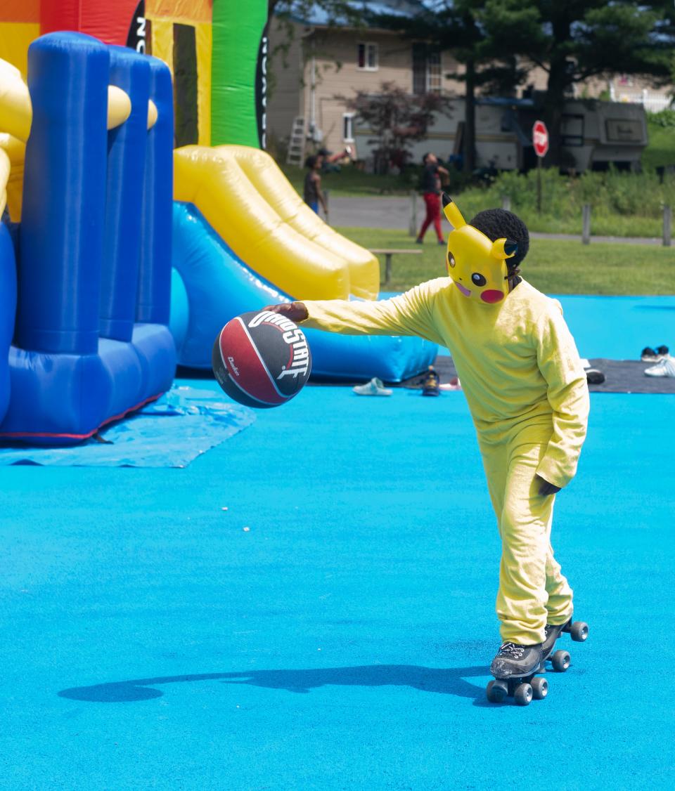 Pokemon, aka 7-year-old Terrance Jones, roller-skates while dribbling a basketball Saturday at the King Kennedy Community Center back-to-school event in Ravenna.