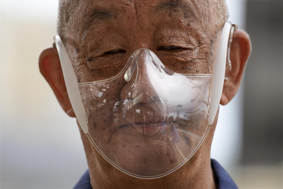 An olympic volunteer wears a mask as he stands at a media bus stop during the 2020 Summer Olympics, Tuesday, Aug. 3, 2021, in Fujisawa, Japan. (AP Photo/Gregorio Borgia)