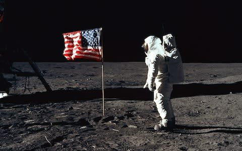 Aldrin poses beside the US flag, which was reinforced with metal so it appears to fly on the windless lunar surface  - Credit: NASA