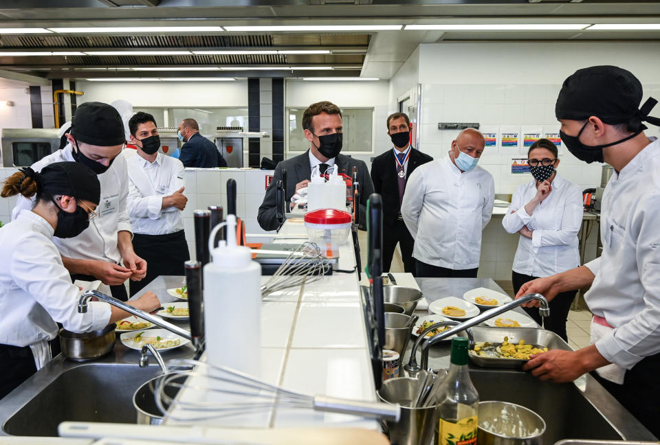 French President Emmanuel Macron looks at students cooking next to Chefs Anne-Sophie Pic, second right, and Chef Thierry Marx, third right, and Anne-Sophie Pic , Tuesday June 8, 2021 in the kitchen of the Hospitality school in Tain-l'Hermitage, southeastern France. (Philippe Desmazes, Pool via AP)