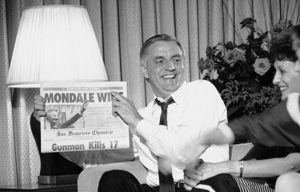 On July 18, 1984, Walter Mondale watches balloting from his hotel room during the Democratic National Convention and holds up the San Francisco Chronicle with the headline "Mondale Wins."