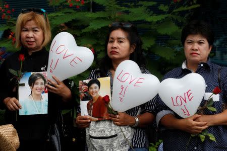 Supporters of ousted former Thai prime minister Yingluck Shinawatra holds a balloon with a sign of nickname and picture of Yingluck, while waiting for her arrival at the Supreme Court in Bangkok, Thailand July 21, 2017. REUTERS/Chaiwat Subprasom