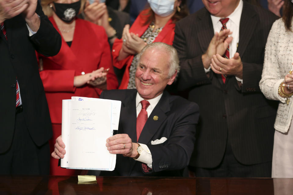 South Carolina Gov. Henry McMaster holds up a bill banning almost all abortions in the state after he signed it into law on Thursday, Feb. 18, 2021, in Columbia, S.C. On the same day, Planned Parenthood filed a federal lawsuit to stop the measure from going into effect. The state House approved the “South Carolina Fetal Heartbeat and Protection from Abortion Act” on a 79-35 vote Wednesday and gave it a final procedural vote Thursday before sending it to McMaster. (AP Photo/Jeffrey Collins)