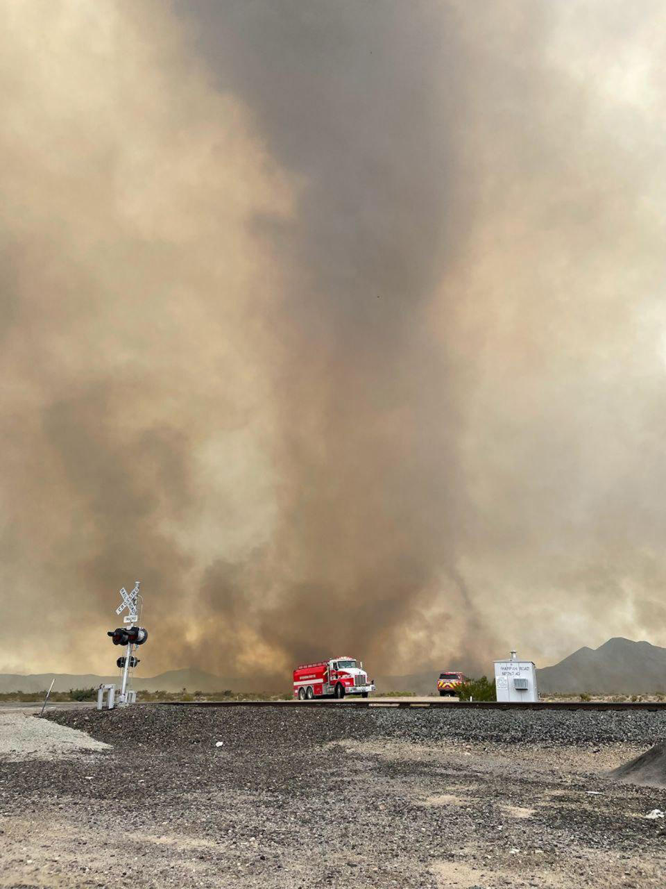 In this photo provided by the National Park Service, smoke rises from the York Fire in the Mojave National Preserve, Calif., Sunday, July 30, 2023. A massive wildfire burning out of control in California's Mojave National Preserve was spreading rapidly amid erratic winds, while firefighters reported progress against another major blaze to the southwest that prompted evacuations. (National Park Service via AP)