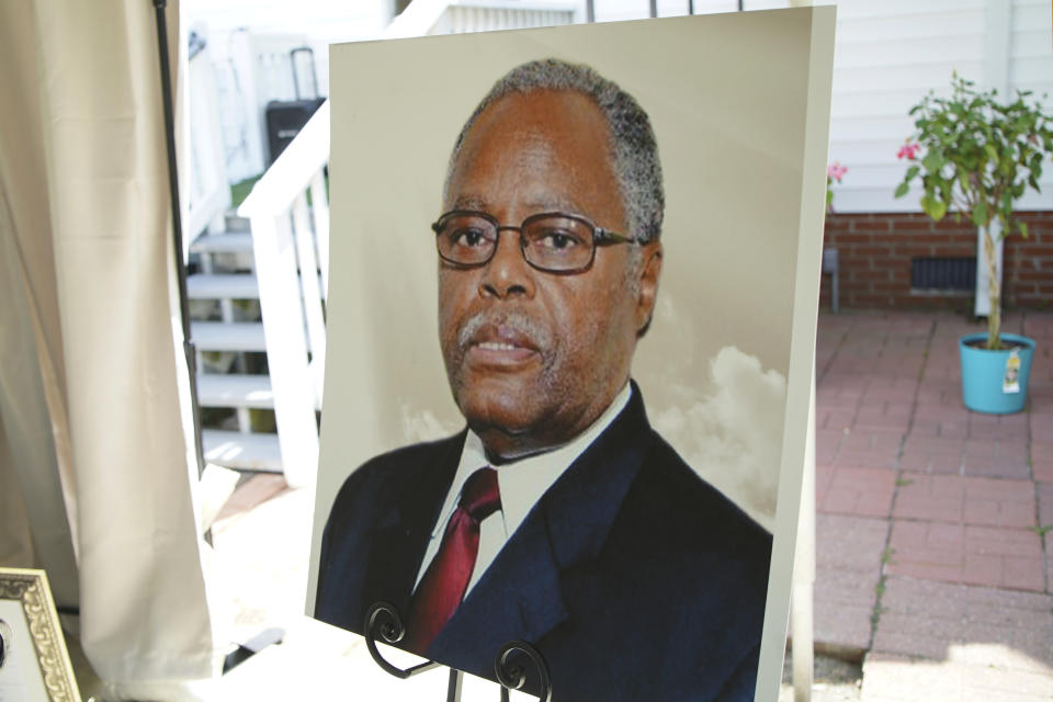 A photo of the late William Penn Troy Sr. stands on an easel during a ceremony in Mullins, S.C., on Saturday, May 22, 2021, to dedicate a local road in his honor. The funeral director and local leader died of COVID-19 in August 2020, one of dozens of Black morticians to succumb during the pandemic. (AP Photo/Allen G. Breed)