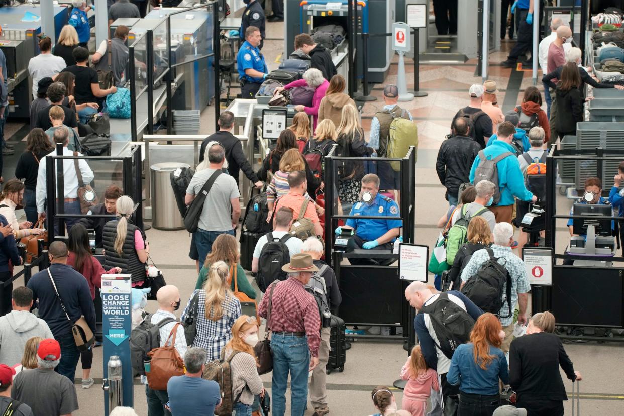 Travelers queue up move through the north security checkpoint in the main terminal of Denver International Airport