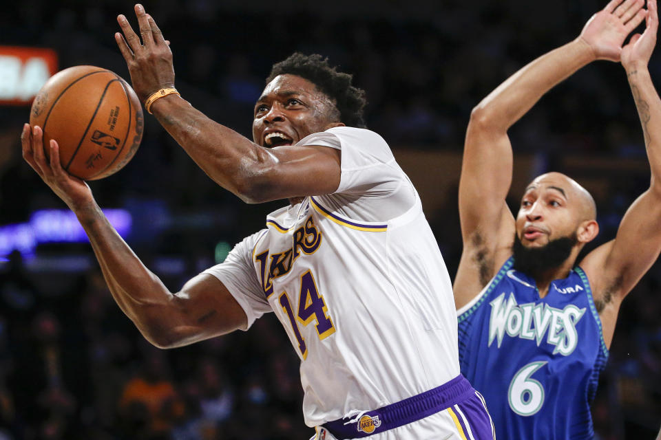 Los Angeles Lakers forward Stanley Johnson (14) drives to basket under pressure from Minnesota Timberwolves guard Jordan McLaughlin (6) during the first half of an NBA basketball game in Los Angeles, Sunday, Jan. 2, 2022. (AP Photo/Ringo H.W. Chiu)