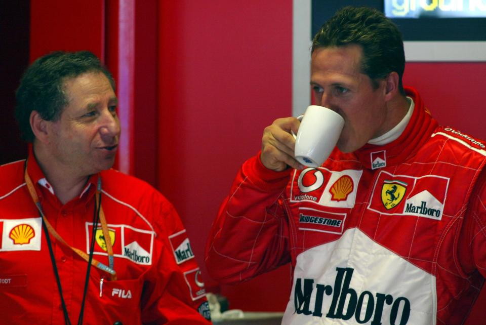 Ferrari's Michael Schumacher, relaxing between sessions sips coffee and chats with Sporting Director Jean Todt