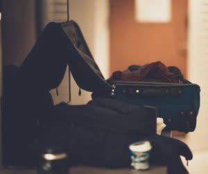 Picture of a suitcase and various unpacked items sitting beside it