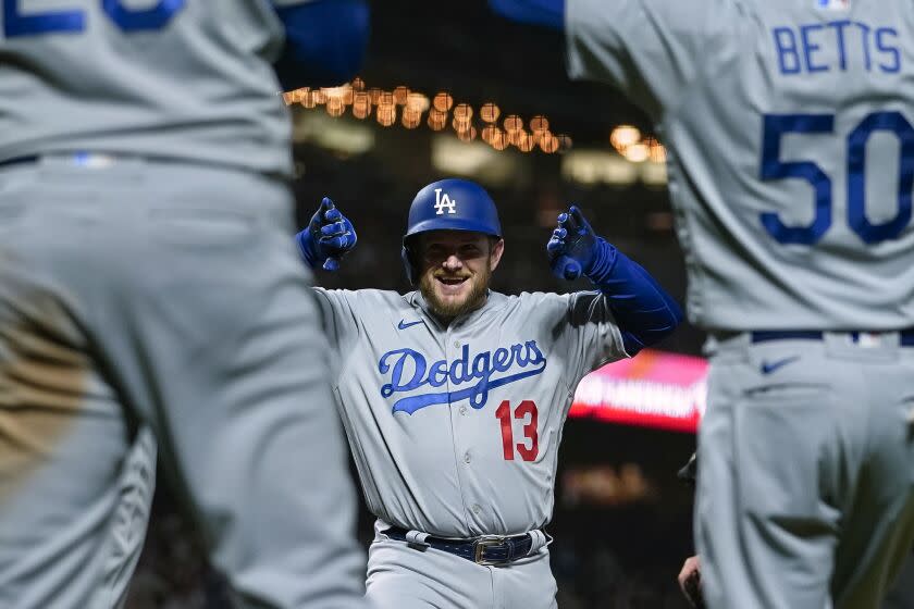 Max Muncy, centro, de los Dodgers de Los Ángeles, celebra con sus compañeros de equipo luego de batear un jonrón de tres carreras contra los Gigantes de San Francisco durante la sexta entrada de un partido de béisbol en San Francisco, el miércoles 12 de abril de 2023. (Foto AP/Godofredo A Vásquez)