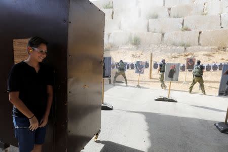 A tourist stands behind a booth as he takes part in a two hour "boot camp" experience, at "Caliber 3 Israeli Counter Terror and Security Academy " in the Gush Etzion settlement bloc south of Jerusalem in the occupied West Bank July 13, 2017. Picture taken July 13, 2017. REUTERS/Nir Elias