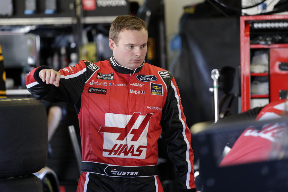 Cole Custer waits in his garage as crew members work on his car during a NASCAR auto race practice at Daytona International Speedway, Saturday, Feb. 8, 2020, in Daytona Beach, Fla. (AP Photo/Terry Renna)