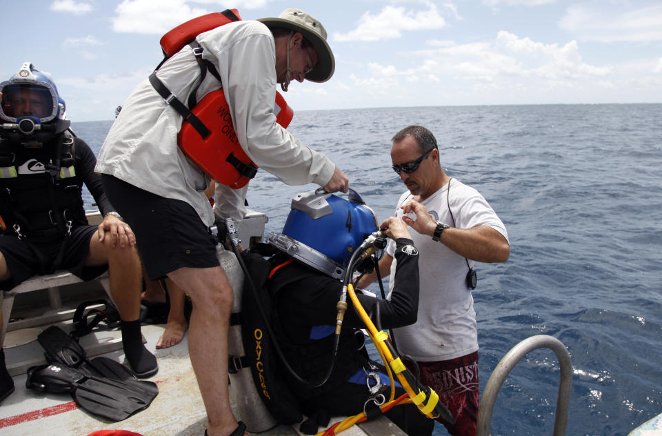 Sylvia Earle, center, puts on her helmet as Dale Stokes, left, and Roger Garcia, right, assist before a dive to the undersea research laboratory Aquarius Reef Base, Friday, July 13, 2012, in the Florida Keys. IN 1970, Earle led the first team of women “aquanauts” to the lab several miles off Key Largo. NOAA owns the lab that has rested for decades some 60 feet below the water’s surface on the Conch Reef in the Florida Keys National Marine Sanctuary. But federal budget cuts threaten to close the undersea lab unless it can secure private funding. (AP Photo/Lynne Sladky)