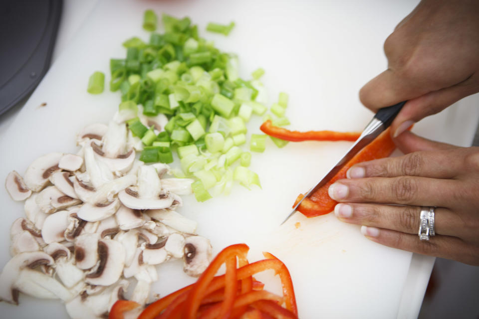 Lockeed Martin senior research scientist Maya Cooper chops vegetables, which would be feasable for astronauts in Mars gravity, for a vegan pizza developed at NASA's Advanced Food Technology Project at Johnson Space Center in Houston Tuesday, July 3, 2012. NASA is currently planning a mission to Mars, which has gravity, so more options for food preparation, like chopping vegetables, are available as opposed to the dehydrated fare of current space missions. (AP Photo/Michael Stravato)