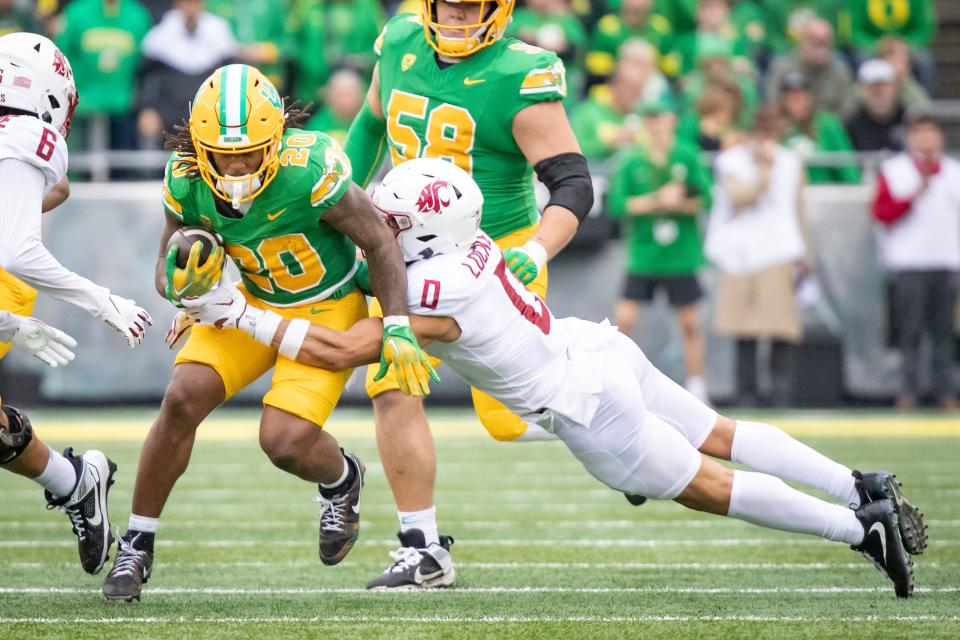 Oregon running back Jordan James tries to shed a tackle by Washington State's Sam Lockett III during the Ducks' 38-24 victory on Oct. 21 at Autzen Stadium. Texas Tech has a road game at Oregon on the 2024 schedule, but is in discussions to substitute a road game at Washington State instead.