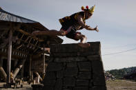 NIAS ISLAND, INDONESIA - FEBRUARY 22: A villager wearing traditional costume jumps over a stone in front of their ancient houses in Bawomataluwo village on February 22, 2013 in Nias Island, Indonesia. Stone Jumping is a traditional ritual, with locals leaping over large stone towers, which in the past resulted in serious injury and death. Stone jumping in Nias Island was originally a tradition born of the habit of inter tribal fighting on the island of Nias. (Photo by Ulet Ifansasti/Getty Images)