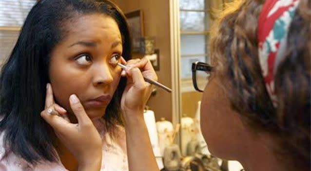 Lauren Thomas (R) applies makeup to her friend, Nita. Photo: Reuters.