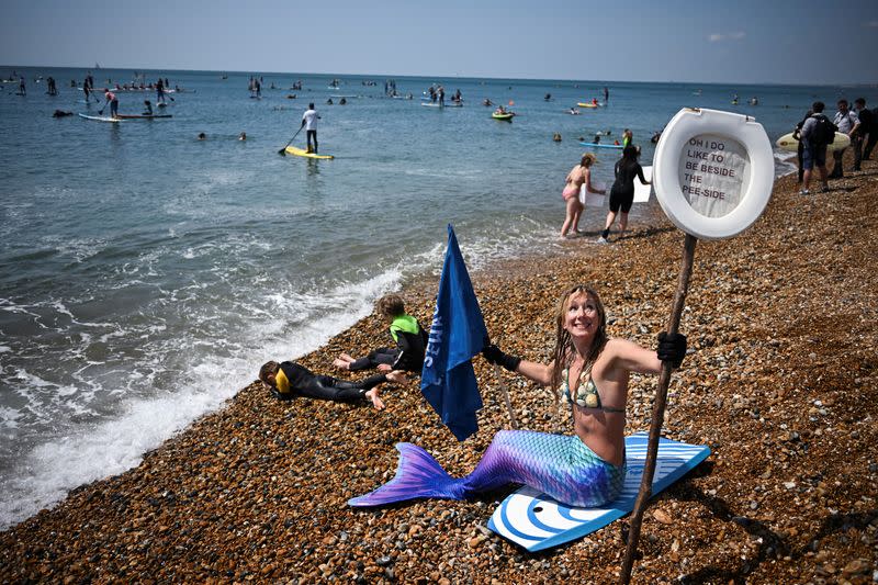 Surfers take part in a mass protest against the continued dumping of untreated sewage by water companies, in Brighton