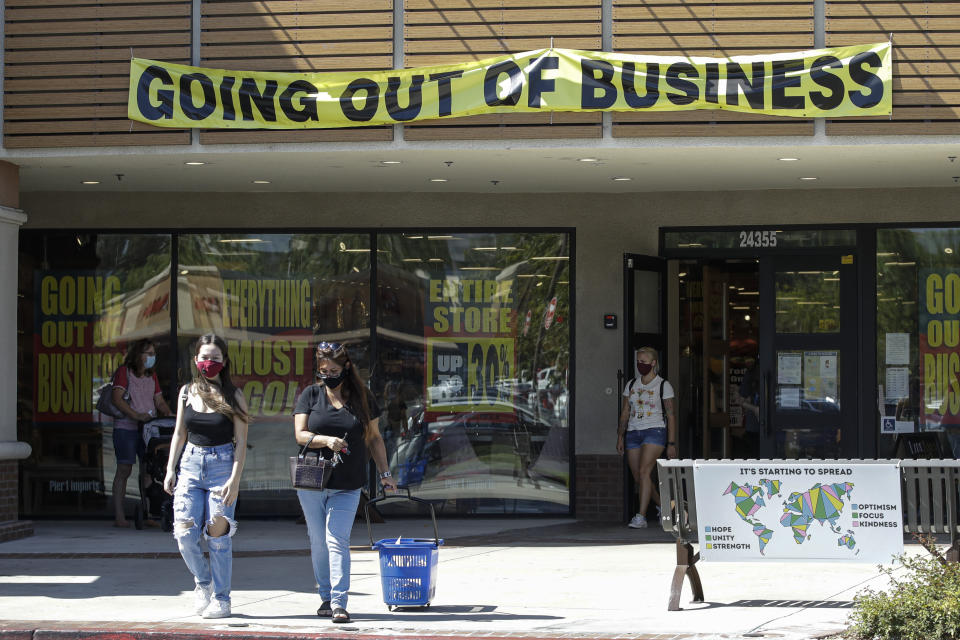 Shoppers walk outside of a Pier 1 Imports store as going out of business signs are posted amid the coronavirus pandemic Wednesday, July 1, 2020, in Santa Clarita, Calif. (AP Photo/Marcio Jose Sanchez)