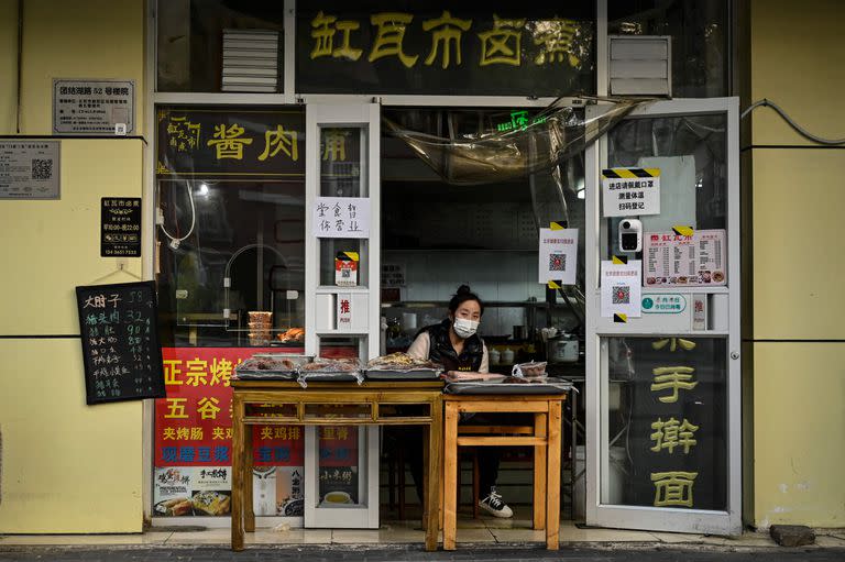 Una mujer espera a los clientes en un restaurante con los servicios de comida suspendidos en el distrito de Chaoyang de Pekín debido a las restricciones del coronavirus Covid-19 el 19 de noviembre de 2022.