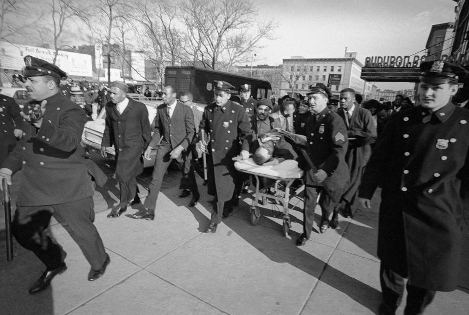 PHOTO: A policeman clears the way as Nationalist leader Malcolm X is carried from the Audubon Ballroom where he was fatally shot on Feb. 21, 1965. (Bettmann Archive via Getty Images, FILE)